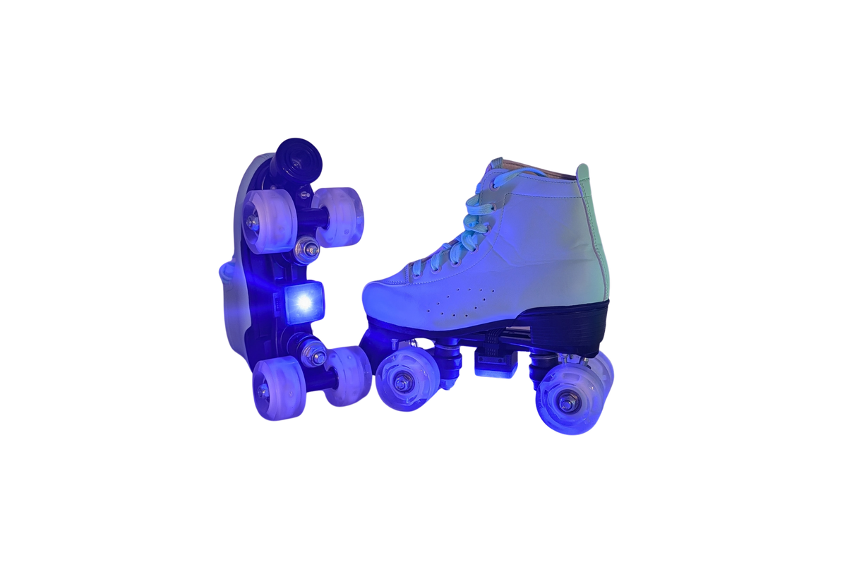 Pair of white roller skates glowing blue with an LED light unit lit on the sole plate of one skate