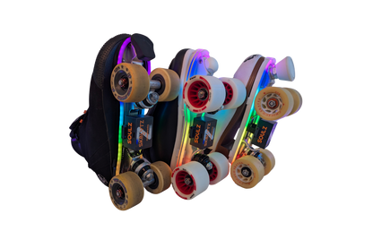 Three quad roller skates in a row, side-on, with rainbow LED light strips and SK8Lytz SOULZ units under the soles