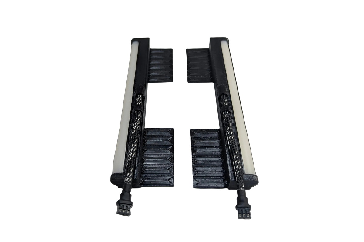 Pair of black LED light rails with white light bars and braided cables ending in connectors, laid flat